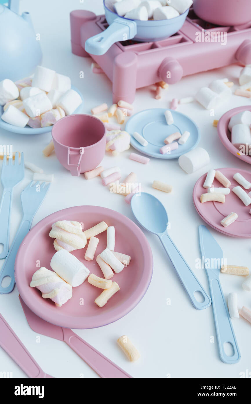 Bunte Plastikgeschirr und Marshmallows auf dem Tisch Stockfoto
