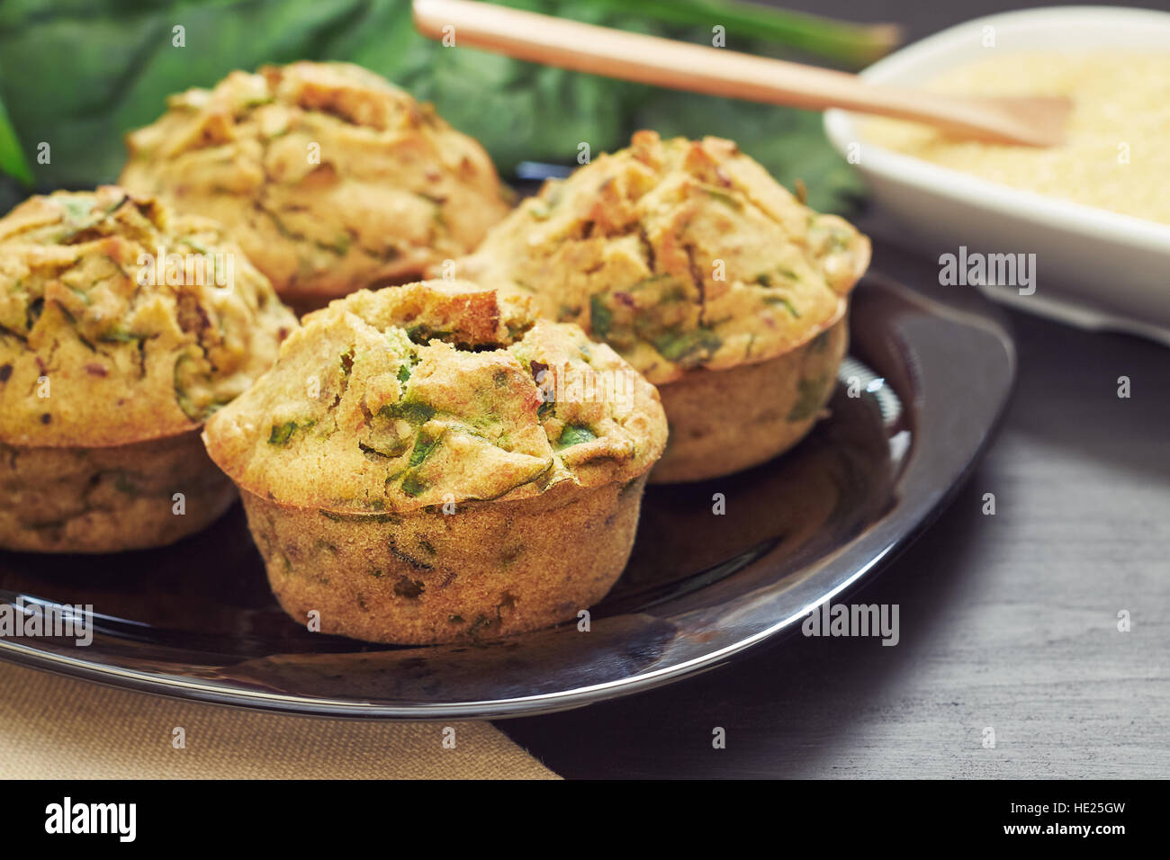 Vegane Muffins mit Spinat und Maismehl serviert auf schwarzem Teller Stockfoto