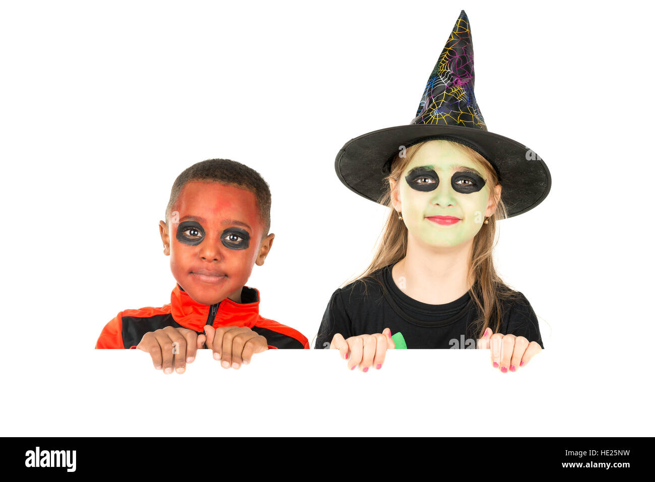 Kinder mit Gesicht malen und Halloween-Kostüme über eine weiße Tafel Stockfoto