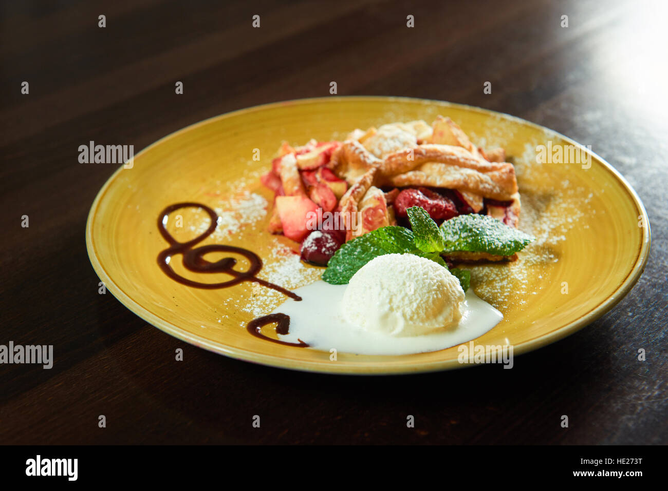 Konditorei-Kunst. Nahaufnahme von einer Kugel Eis auf einen Teller mit einem Stück Obst-Strudel Stockfoto