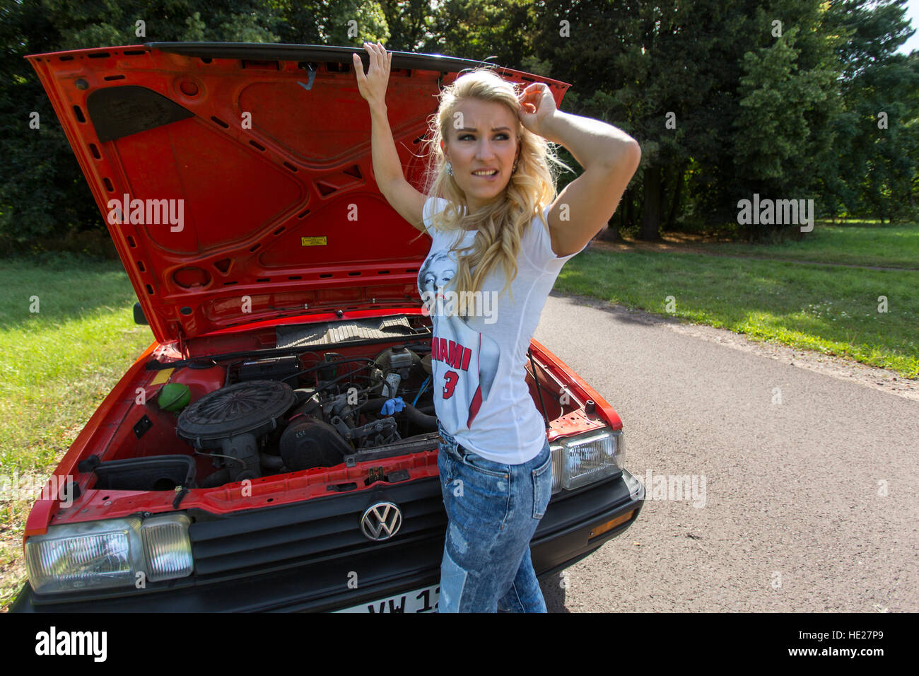 Bionde Frau und ein rotes Auto Stockfoto