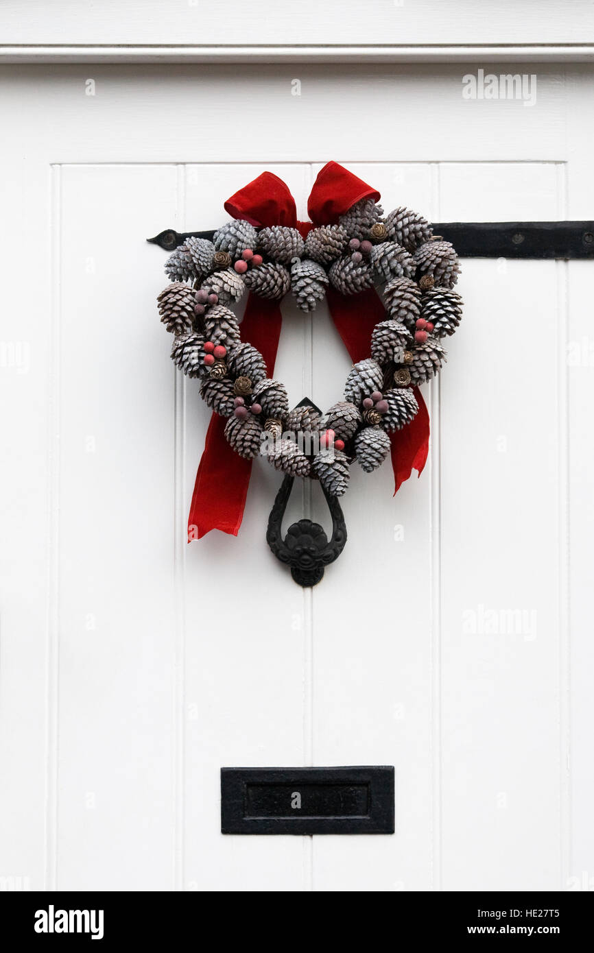 Dekorative weihnachten Kranz Aufhängen an einer weißen Tür. Stockfoto
