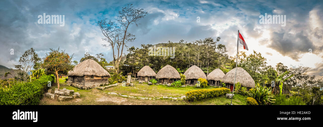 Panoramablick über traditionelle Häuserzeile mit Stroh Dächer im Dorf mit Fahne in Dani Schaltung in der Nähe von Wamena, Papua, Indonesien. Stockfoto