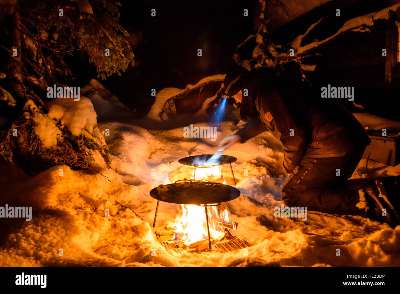 Kochen auf schwedischen Grillen über offenem Feuer, draußen im Schnee, Schweden Stockfoto