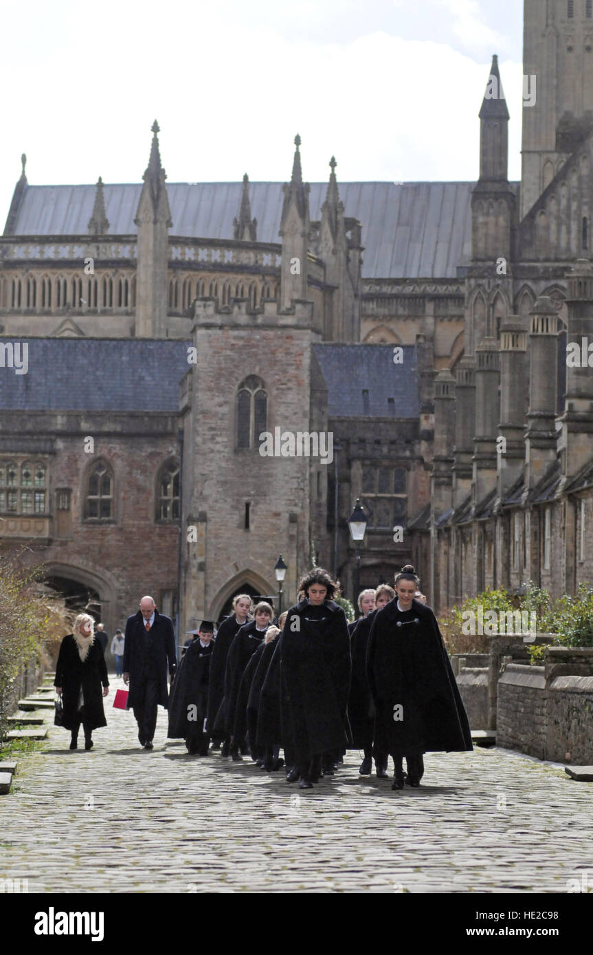 Chorsänger aus Wells Cathedral Choir entlang enger Vikare mit Wells Cathedral im Hintergrund, am Ostersonntag. Stockfoto