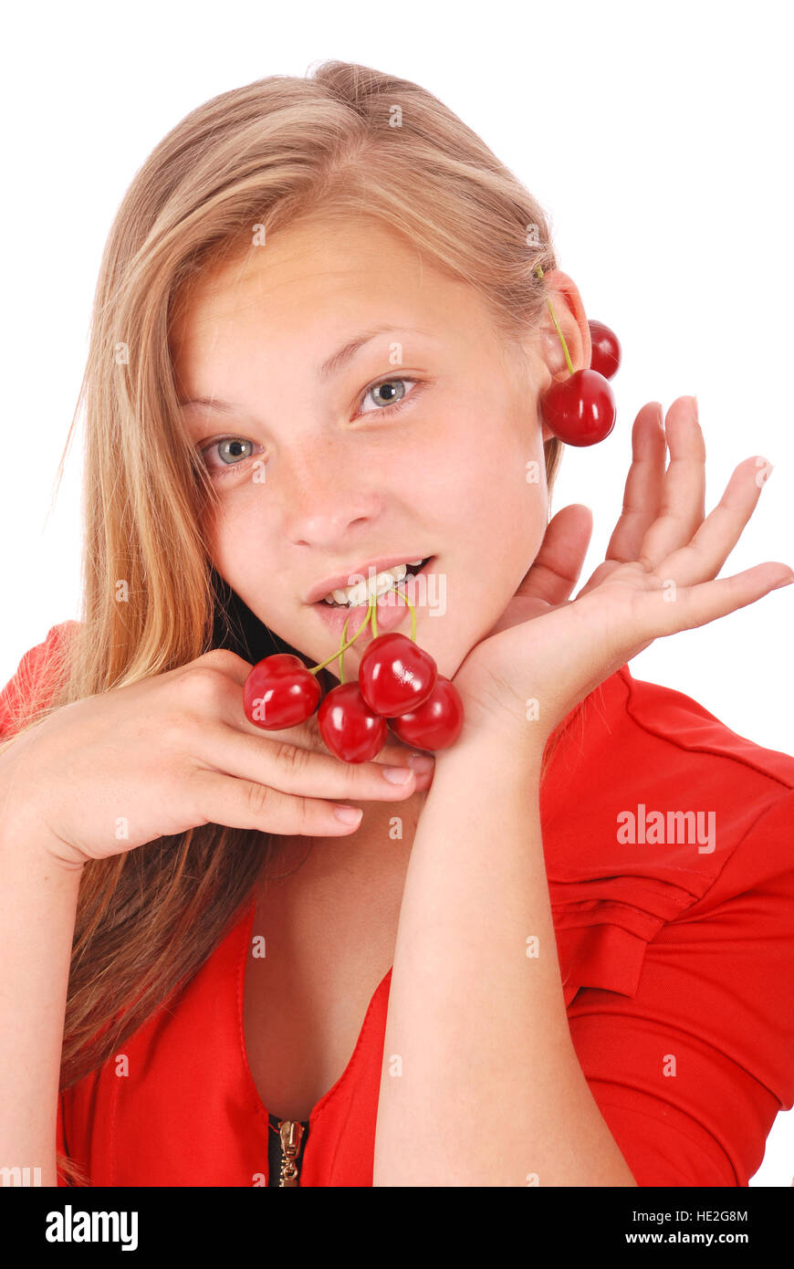 Mädchen in Lippen halten frische Kirschen, isoliert auf weiss Stockfoto