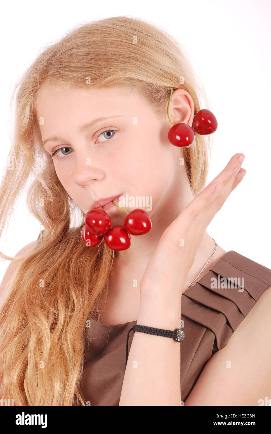 Mädchen in Lippen halten frische Kirschen, isoliert auf weiss Stockfoto