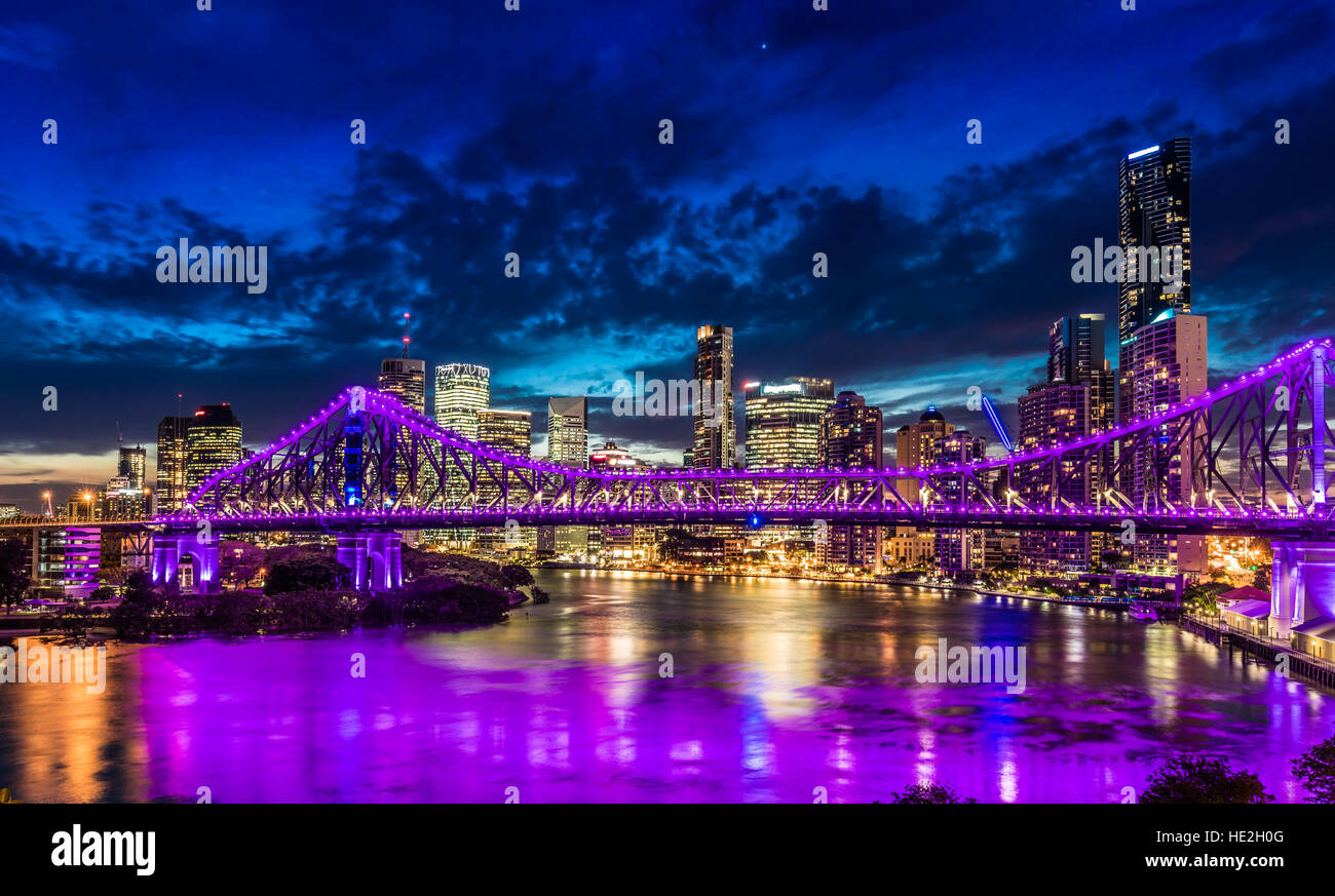 Pulsierende Nacht Zeit Panorama von Brisbane mit lila leuchtet auf Story Bridge, Australien Stockfoto