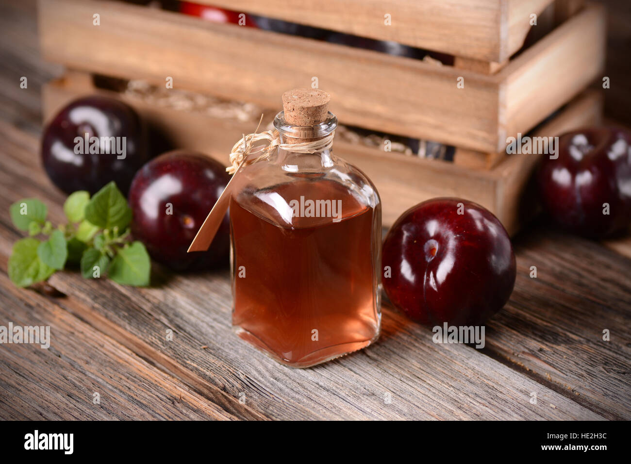 Pflaumensaft in kleine Glasflasche mit Früchten um Stockfoto