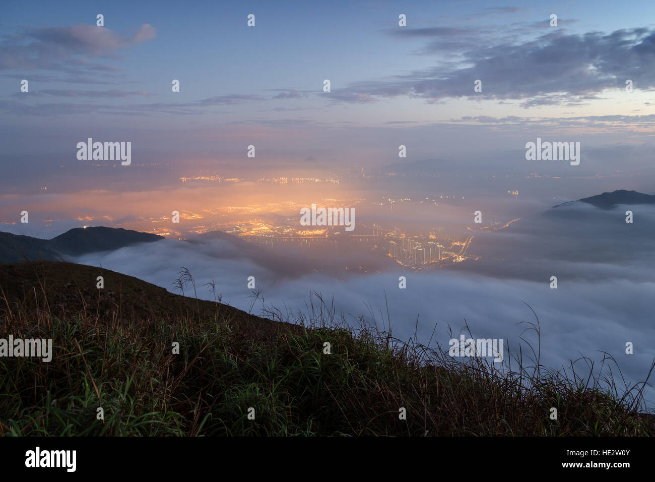 Lichter der Tung Chung Neustadt unter Wolken auf Lantau Island, gesehen vom Lantau Peak auf Lantau Island in Hongkong, China. Stockfoto