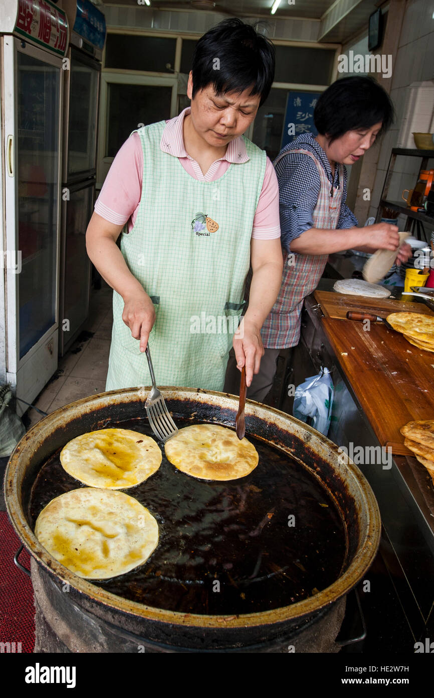 Hui uigurischen Frau bereitet Essen Braten Nang flache Brot muslimischen Viertel Markt Xian, China. Stockfoto