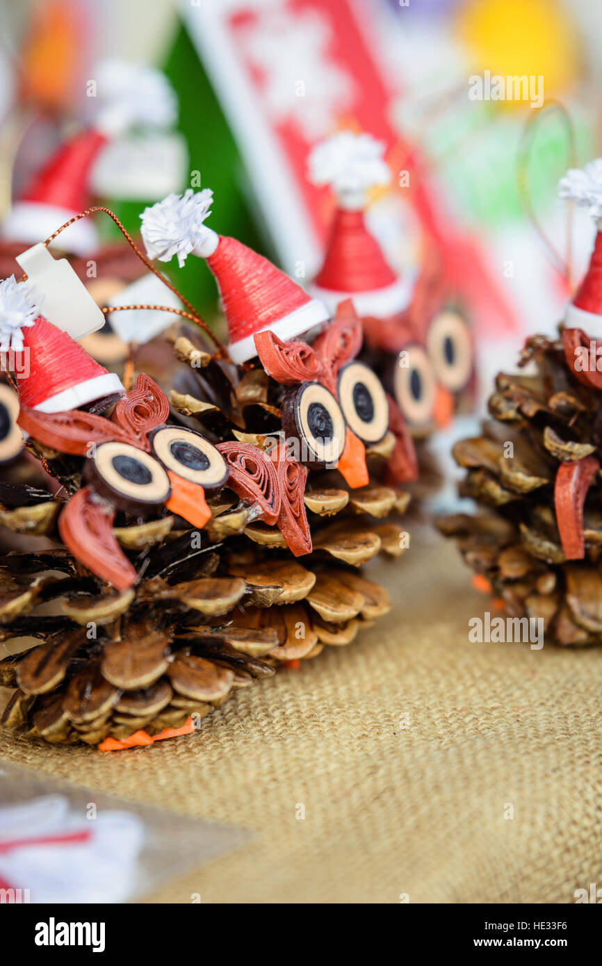 Weihnachts-Dekoration mit Tannenzapfen. Vögel aus Tannenzapfen mit Santa Hüte hergestellt. Stockfoto