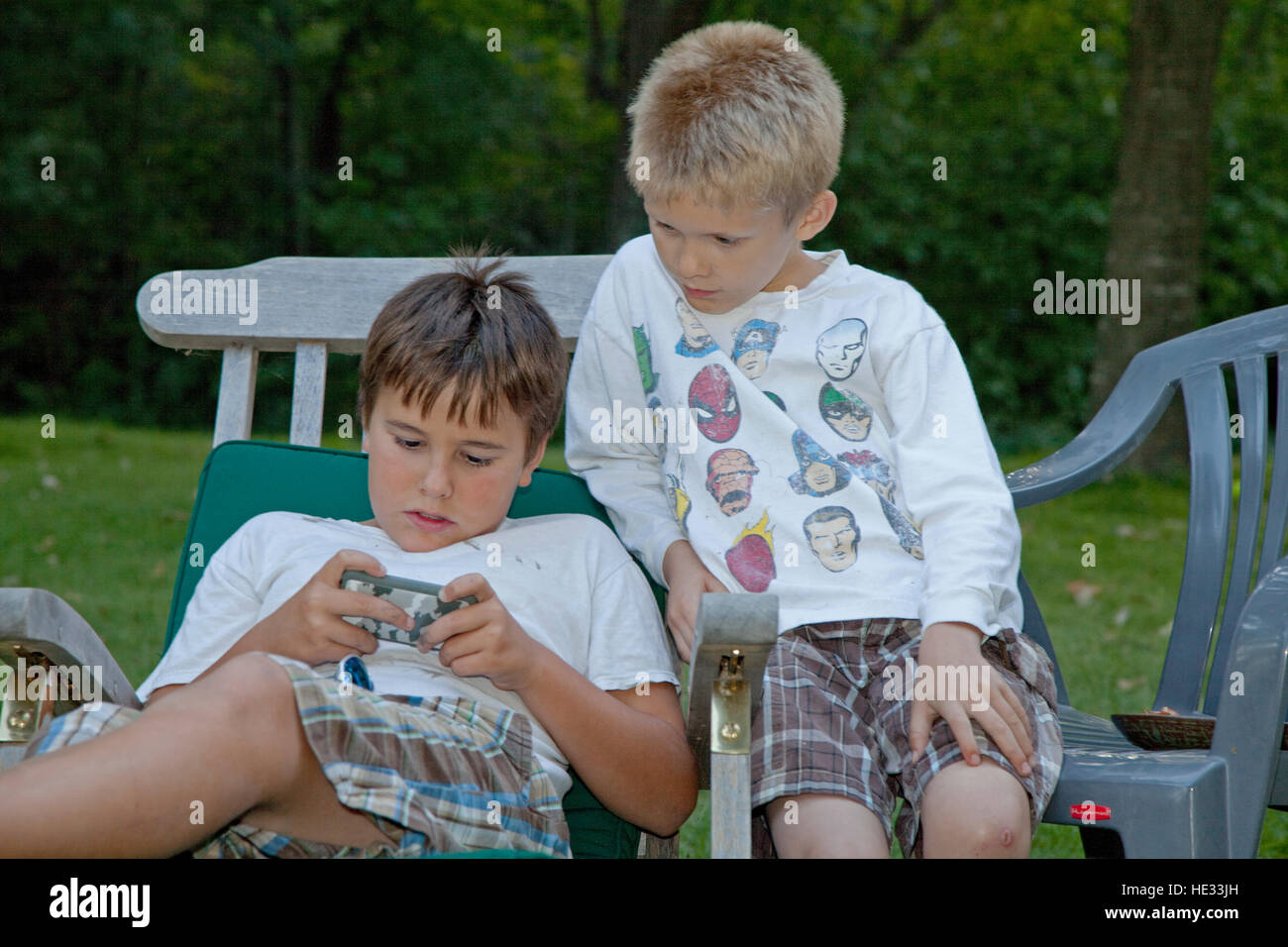 Jungen adsorbiert 10 Jahre elektronische Videospiel auf Handy spielen. Clitherall Minnesota MN USA Stockfoto