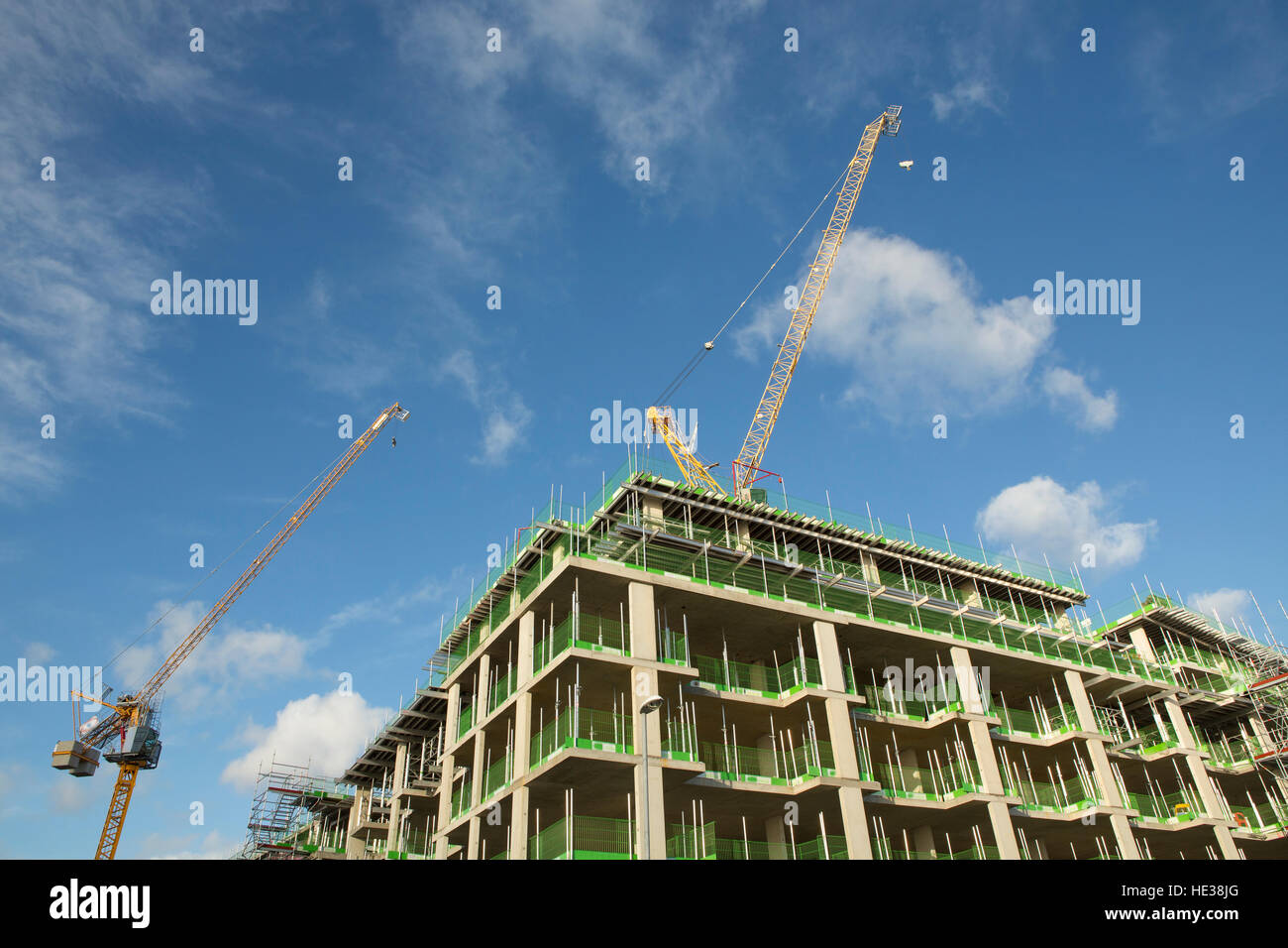 Paar Baukräne auf ein neues Gebäude. Blauer Himmel und weiße Wolken Stockfoto