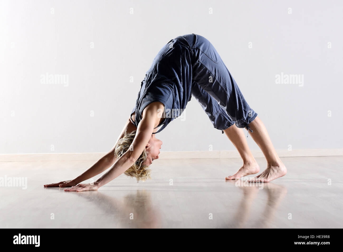 Geschmeidige barfuß junge Frau, trainieren Sie im Fitnessraum tun stretching-Übungen in einem niedrigen Winkel-Seitenansicht Stockfoto