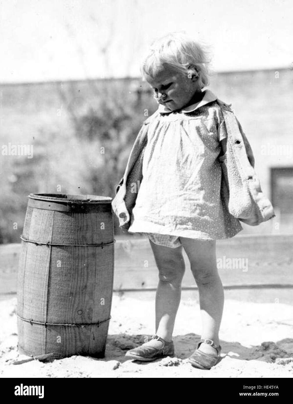 Dieses historische Foto zeigt ein Mädchen, das in einem Sandkasten in einer FERA-Gärtnerei steht und 1930 die Rolle der Kindergärten während der Großen Depression in den Vereinigten Staaten feststellt. Stockfoto