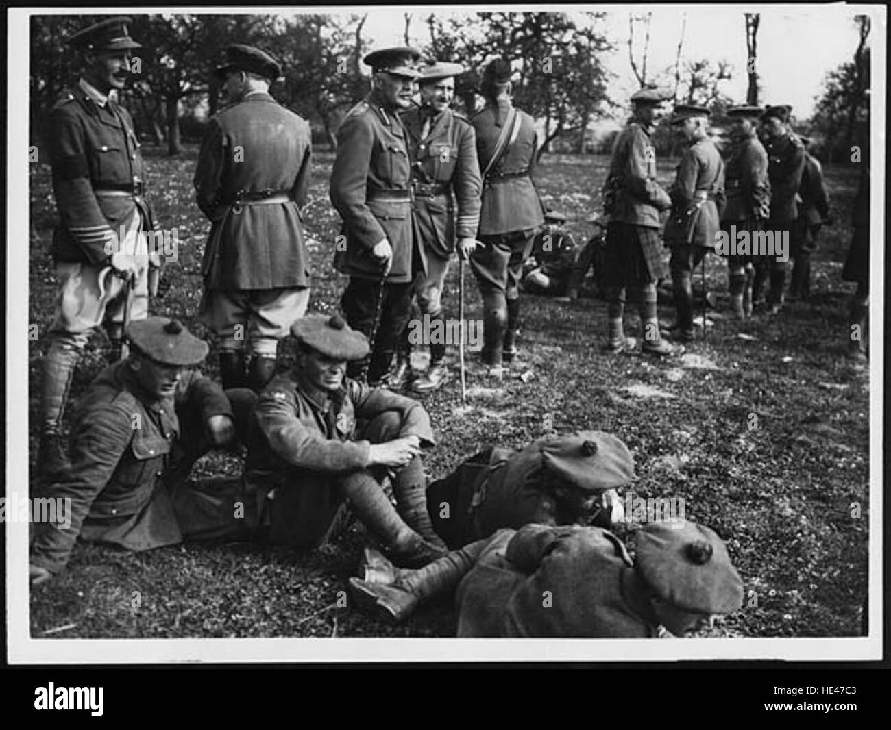 Dieses historische Foto zeigt den Divisional Commander und den Stab, der den Flug eines Gewehrs beobachtet und die militärische Bedeutung und das taktische Bewusstsein der Zeit unterstreicht. Sie spiegelt die Disziplin und den Schwerpunkt des Militärpersonals in einem Ausbildungs- oder Kampfkontext wider. Stockfoto
