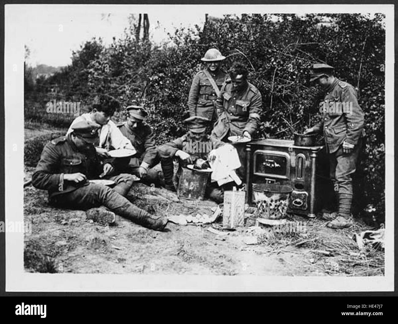 Dieses Foto zeigt britische Soldaten oder „Tommies“, die während des Ersten Weltkriegs auf einem echten Herd gekocht wurden. Es bietet einen seltenen Moment der Ruhe inmitten der Not, denen Soldaten während des Konflikts ausgesetzt waren, und unterstreicht die Bedeutung von Essen und Wärme für die Aufrechterhaltung der Moral. Stockfoto