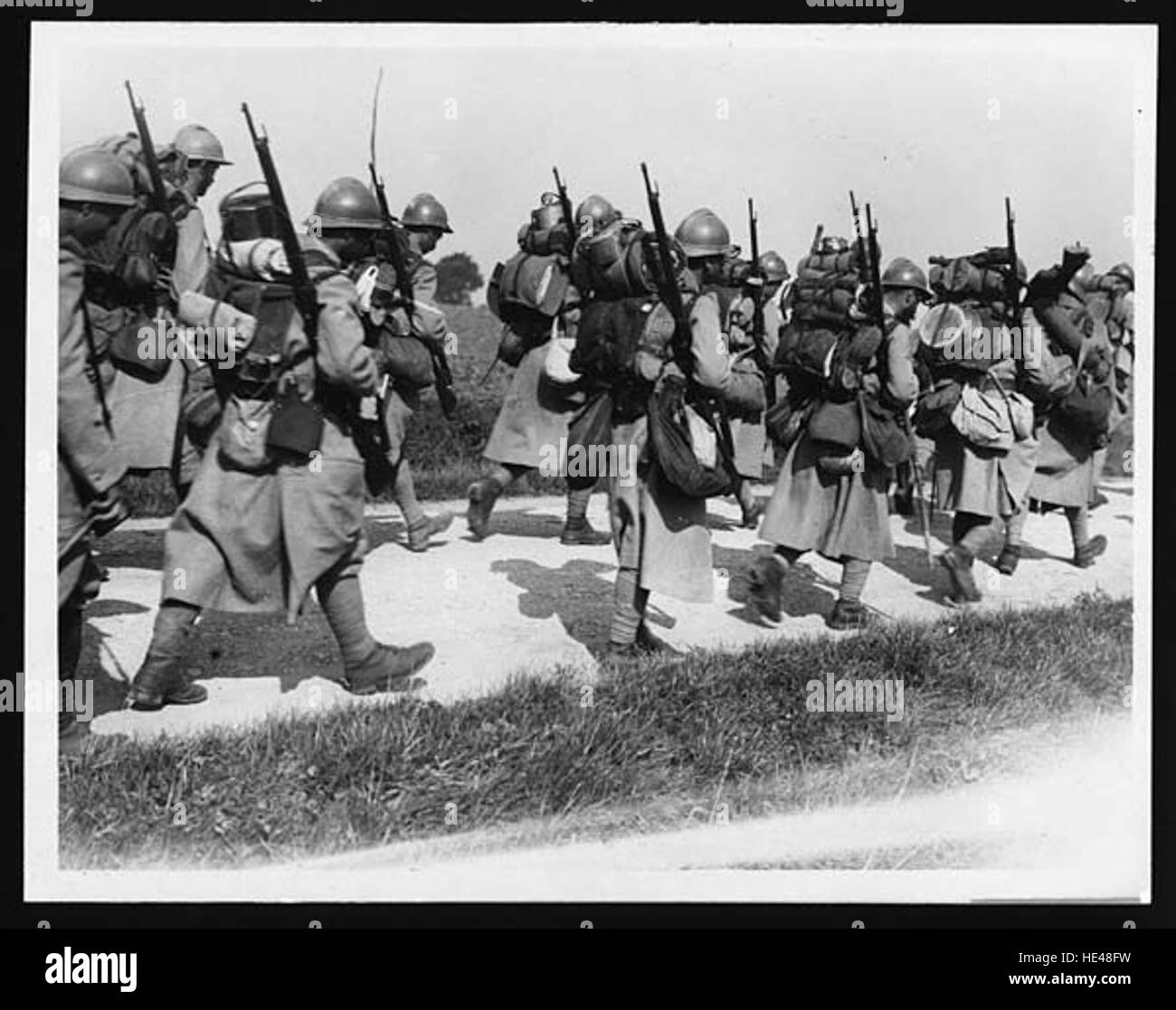 Dieses historische Bild zeigt französische Truppen, die während des Ersten Weltkriegs auf die Frontlinien marschieren. Das Foto fängt die düstere Stimmung und das immense Ausmaß der militärischen Mobilisierung während des Ersten Weltkriegs ein. Stockfoto