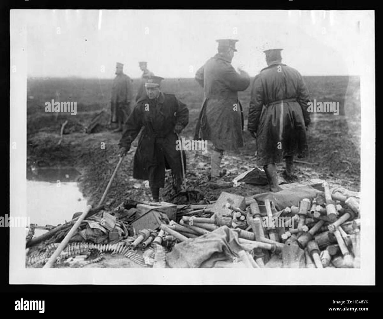 Dieses historische Bild zeigt spanische Offiziere, die einen großen Stapel gefangener deutscher Handgranaten inspizieren. Die Szene reflektiert die Nachwirkungen militärischer Auseinandersetzungen während des Krieges und hebt die bedeutende Rolle der gefangenen feindlichen Waffen in Kriegsstrategien hervor. Stockfoto