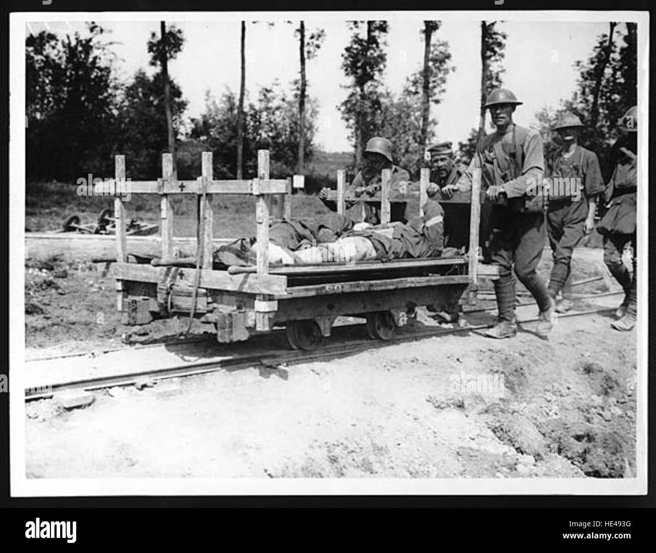 Ein historisches Foto, das deutsche Gefangene zeigt, wie sie während des Ersten Weltkriegs britische verwundete Soldaten in die Nähe von Messines brachten. Dieses Bild zeigt die düsteren Realitäten des Krieges und unterstreicht die Interaktion zwischen feindlichen Kämpfern unter schrecklichen Umständen. Stockfoto