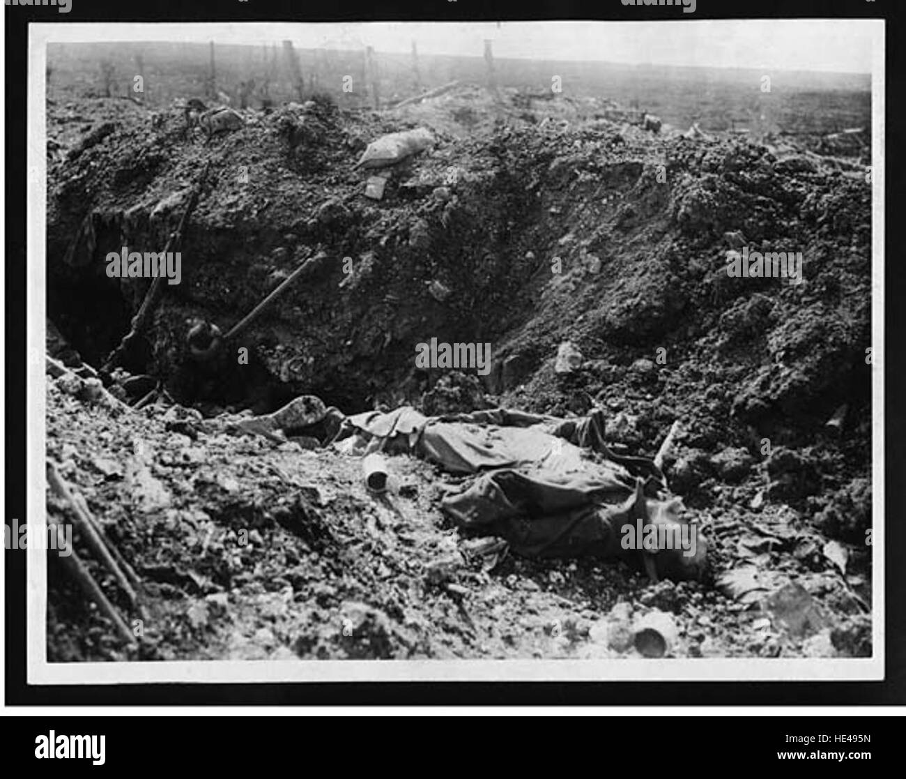 Dieses historische Foto zeigt die Nachwirkungen einer Schlacht während des Ersten Weltkriegs, bei der die Leichen deutscher Soldaten in einem Gefangenengraben liegen. Das Bild erinnert stark an die Zerstörung und die brutale Realität des Krieges. Stockfoto
