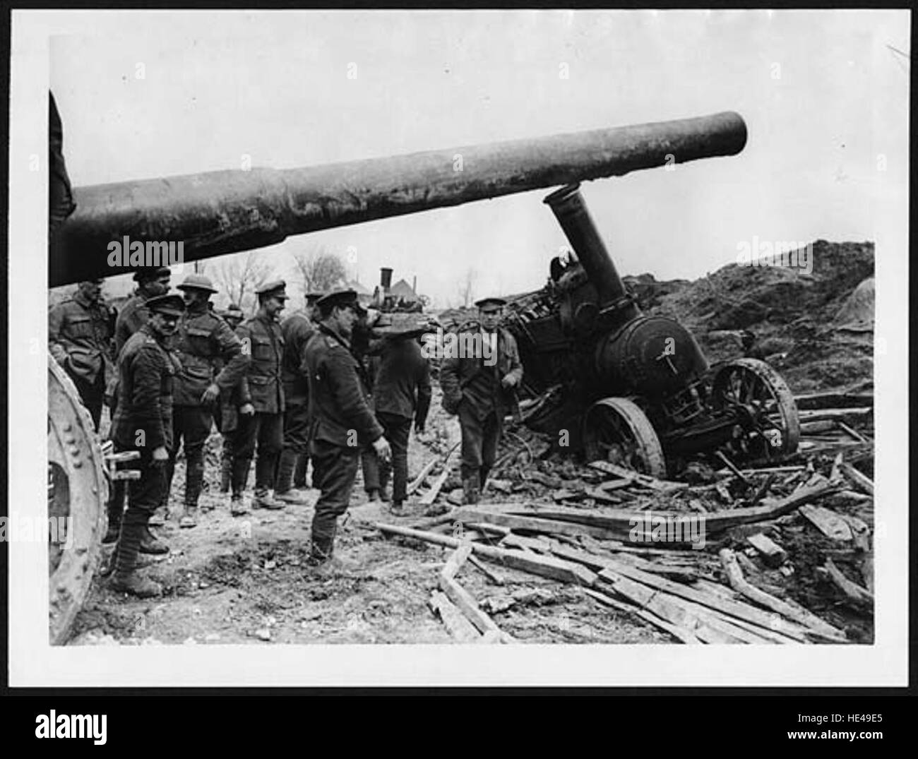 Ein historisches Foto, das eine große Pistole zeigt, die transportiert wird, wobei der Traktor Schwierigkeiten hat. Dieses Bild verdeutlicht die Herausforderungen, die mit dem Transport schwerer Artillerie verbunden sind, und die logistische Komplexität militärischer Operationen in der Vergangenheit. Stockfoto
