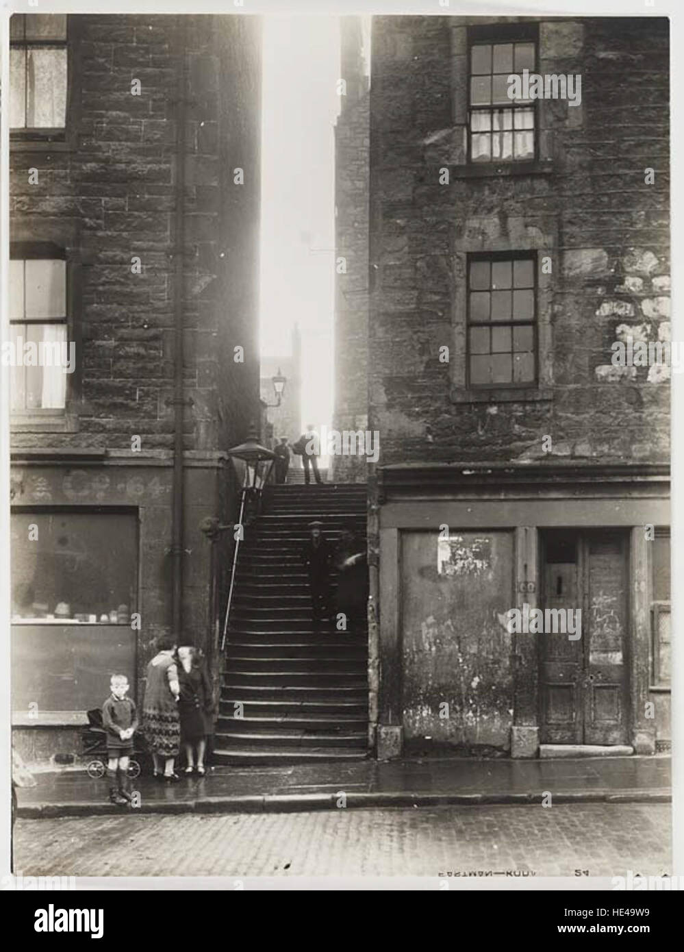 Ein historisches Foto, das einen Treppenflug zwischen zwei Gebäuden zeigt und das architektonische Design einer früheren Ära symbolisiert. Dieses Bild spiegelt die Architektur- und Stadtgeschichte vergangener Gesellschaften wider. Stockfoto