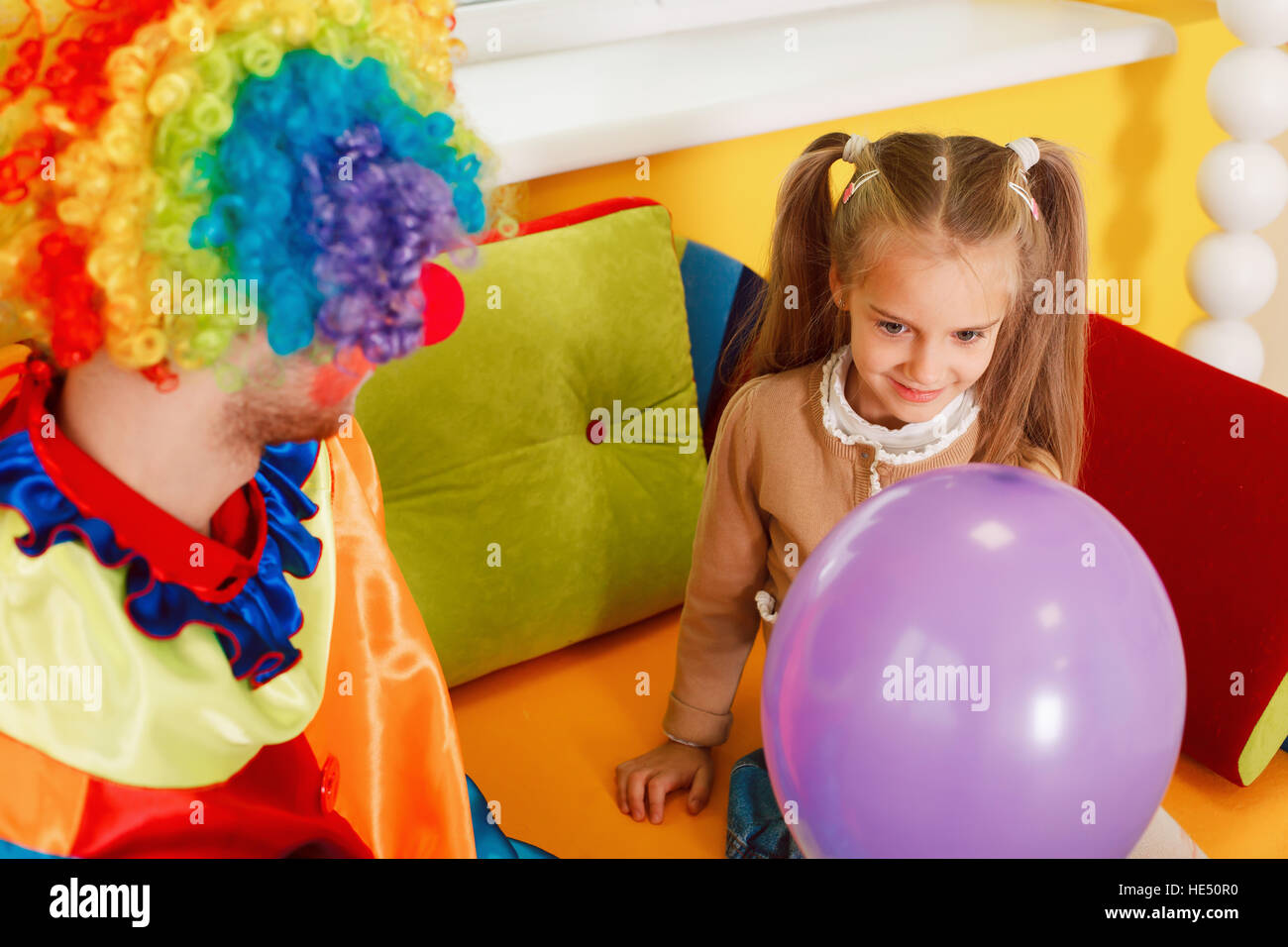 Lustige Clown geben Luftballon, das kleine Mädchen Stockfoto