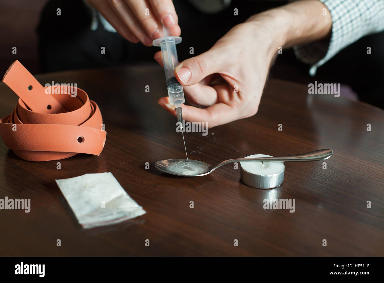 Süchtiger Mensch sammelt eine Dosis Heroin in Spritze. Stockfoto