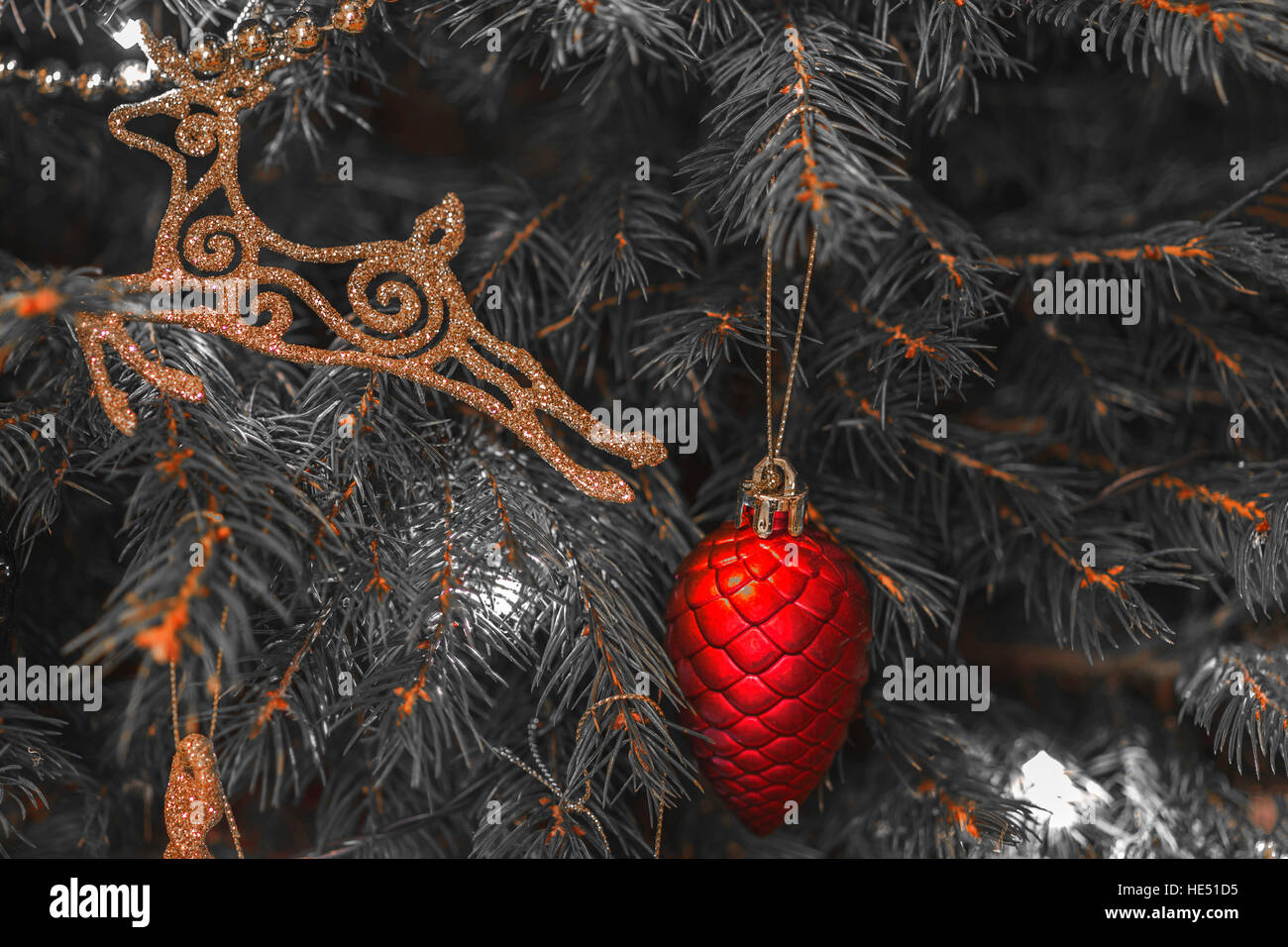 Christbaumschmuck - rot gestylten Tannenzapfen und goldenen Hirsch - stilisierte Bild, die meisten der Farbe entfernt - Duo getönt Stockfoto