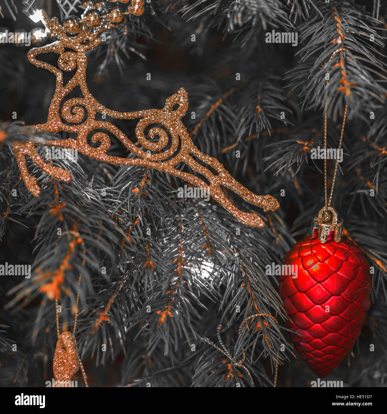 Christbaumschmuck - rot gestylten Tannenzapfen und goldenen Hirsch - stilisierte Bild, die meisten der Farbe entfernt - Duo getönt Stockfoto
