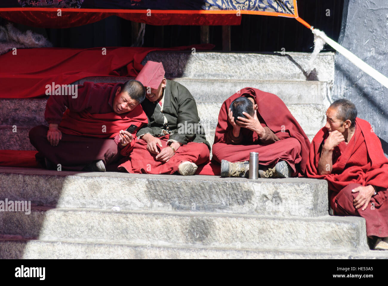 Lhasa: Kloster Sera; Sera Je-Fakultät; Lachende Mönche Lesen einer SMS, Handy, Tibet, China Stockfoto