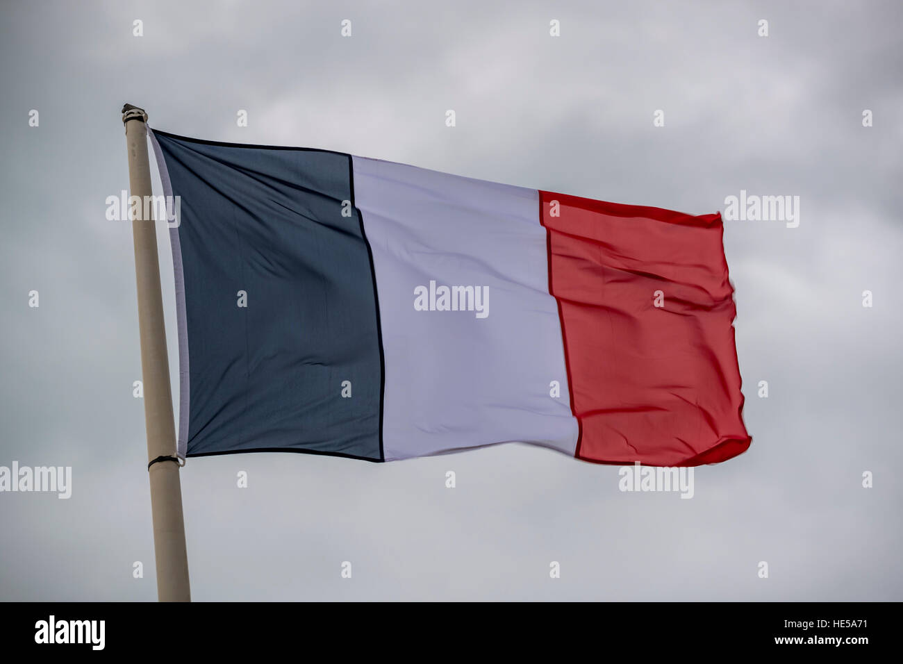 Französische Flagge, die bei starkem Wind an der Küste von Dünkirchen, Frankreich. Stockfoto