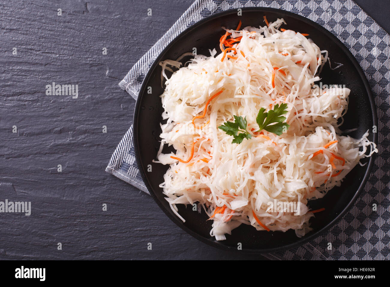 hausgemachte Sauerkraut mit Karotten in einer schwarzen Platte horizontale Ansicht von oben Stockfoto