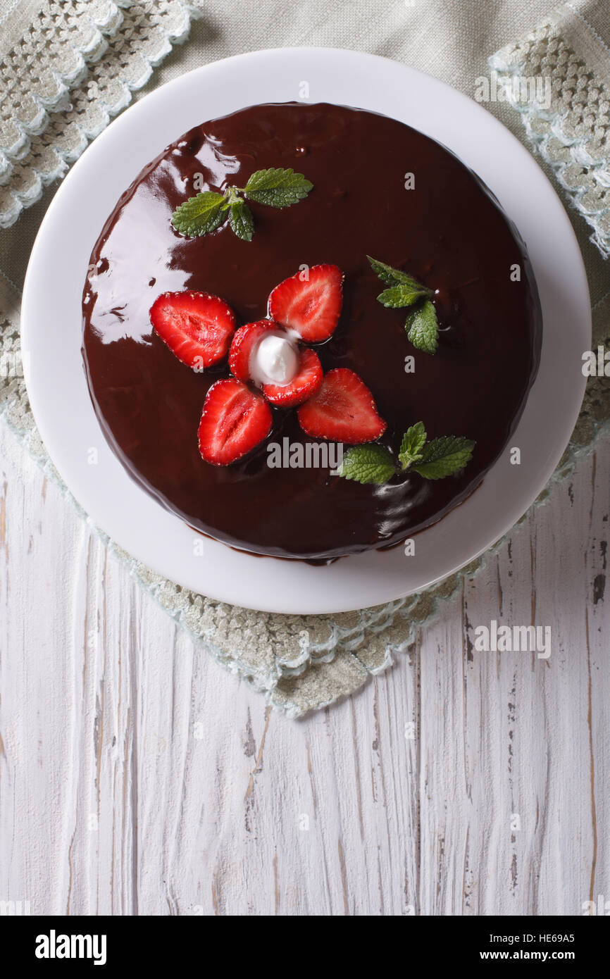 Frische Schokolade Kuchen mit Erdbeeren auf einem Tisch. vertikale Ansicht von oben Stockfoto