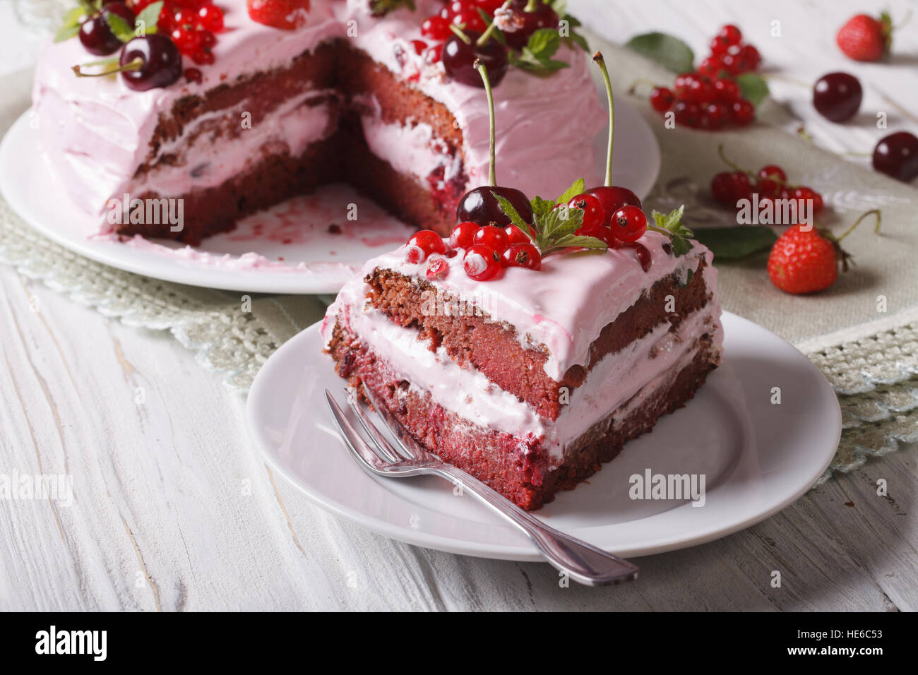 Das geschnittene Stück Beere Torte mit rosa Creme mit einer Platte Großaufnahme. horizontale Stockfoto