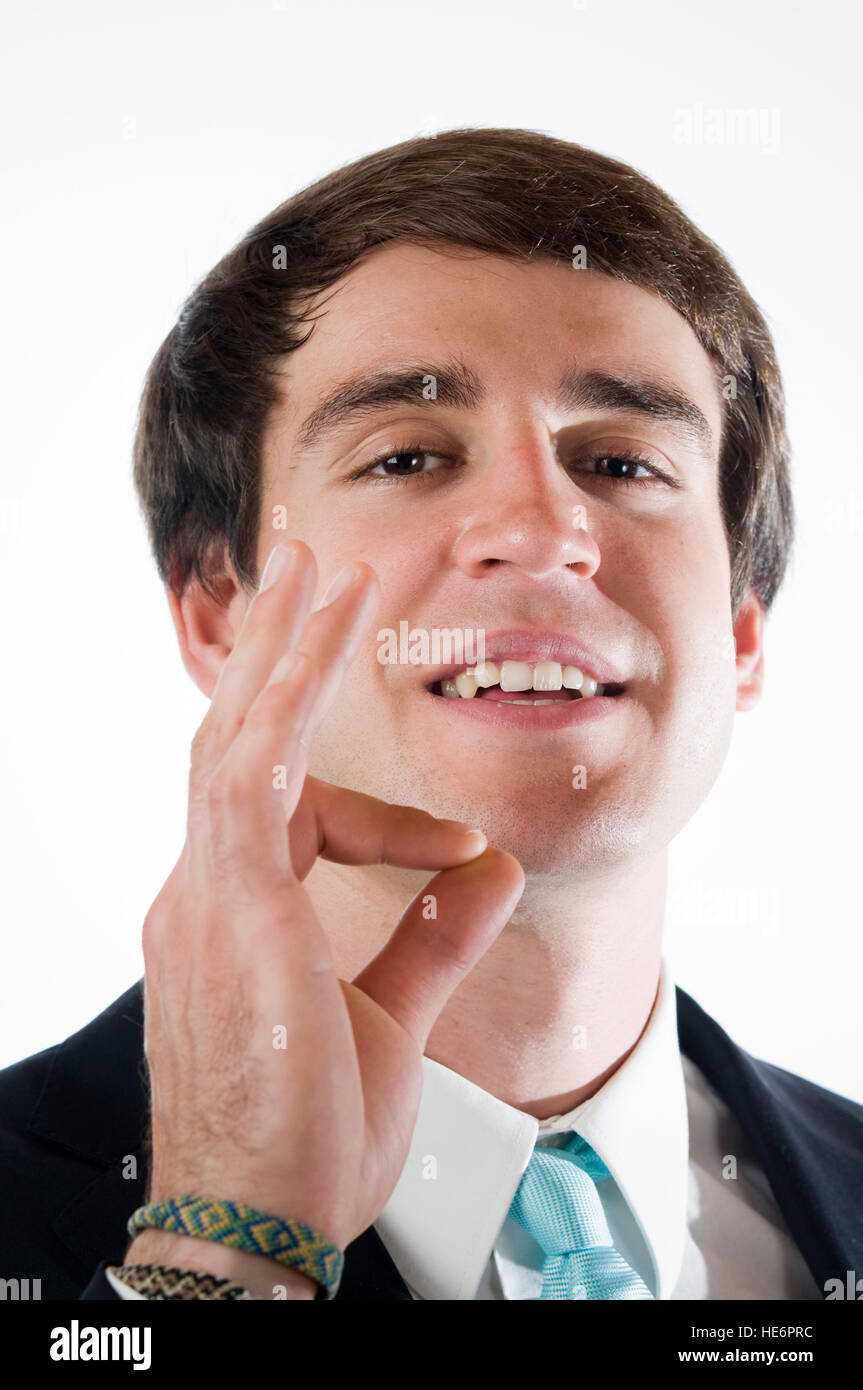 Kopf und Schulter Blick eines jungen Mannes in Business Kleid zeigt die "OK" Zeichen vor weißem Hintergrund mit der rechten Hand. Stockfoto