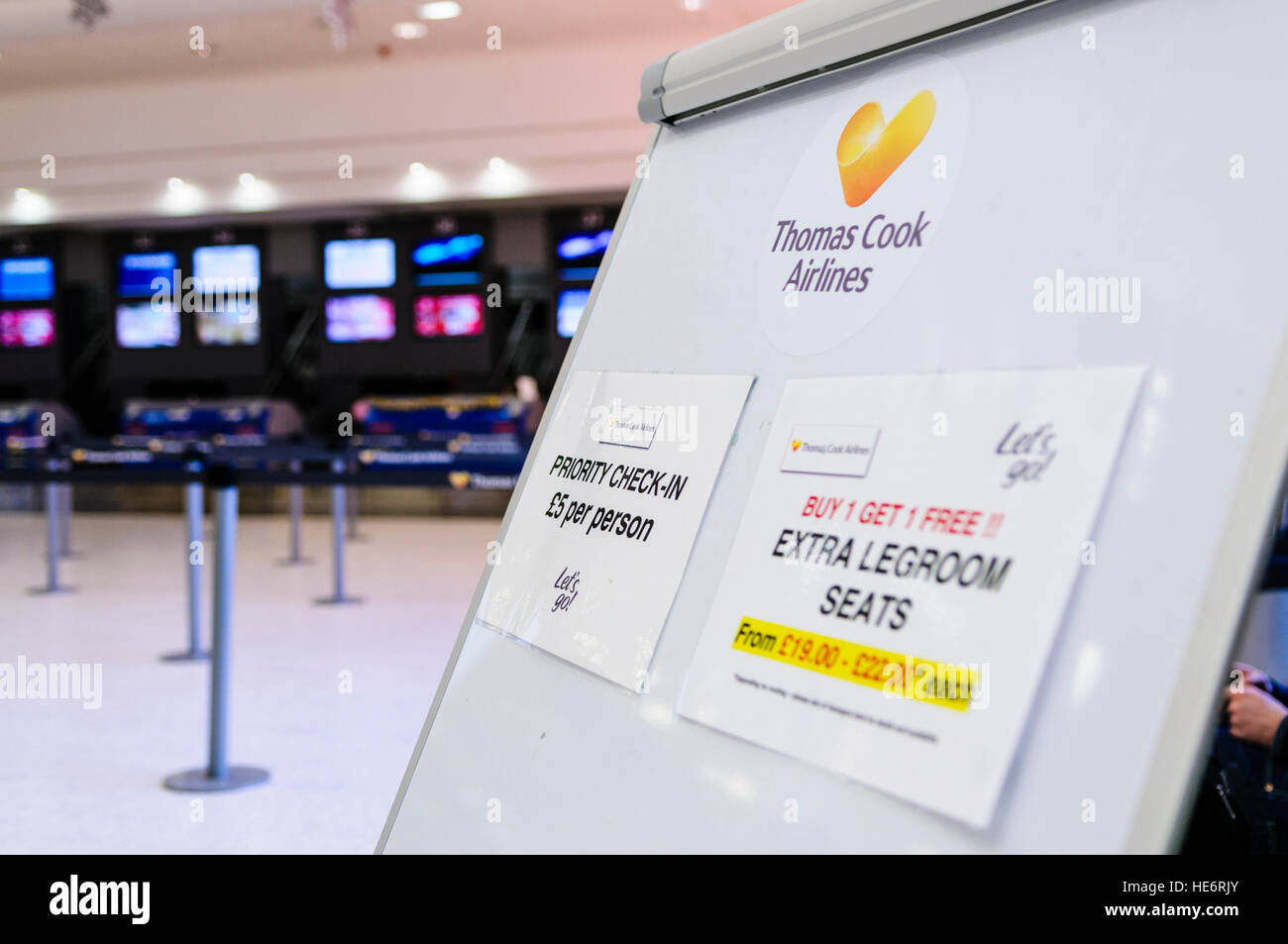 Board bei einem Thomas Cook Airlines Check-in-Schalter bietet Upgrades für Priority-Check-in oder mehr Beinfreiheit Sitze. Stockfoto