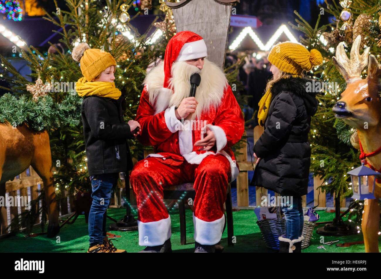 Santa Weihnachtsmann im Gespräch mit zwei jungen Mädchen in seiner Grotte Stockfoto