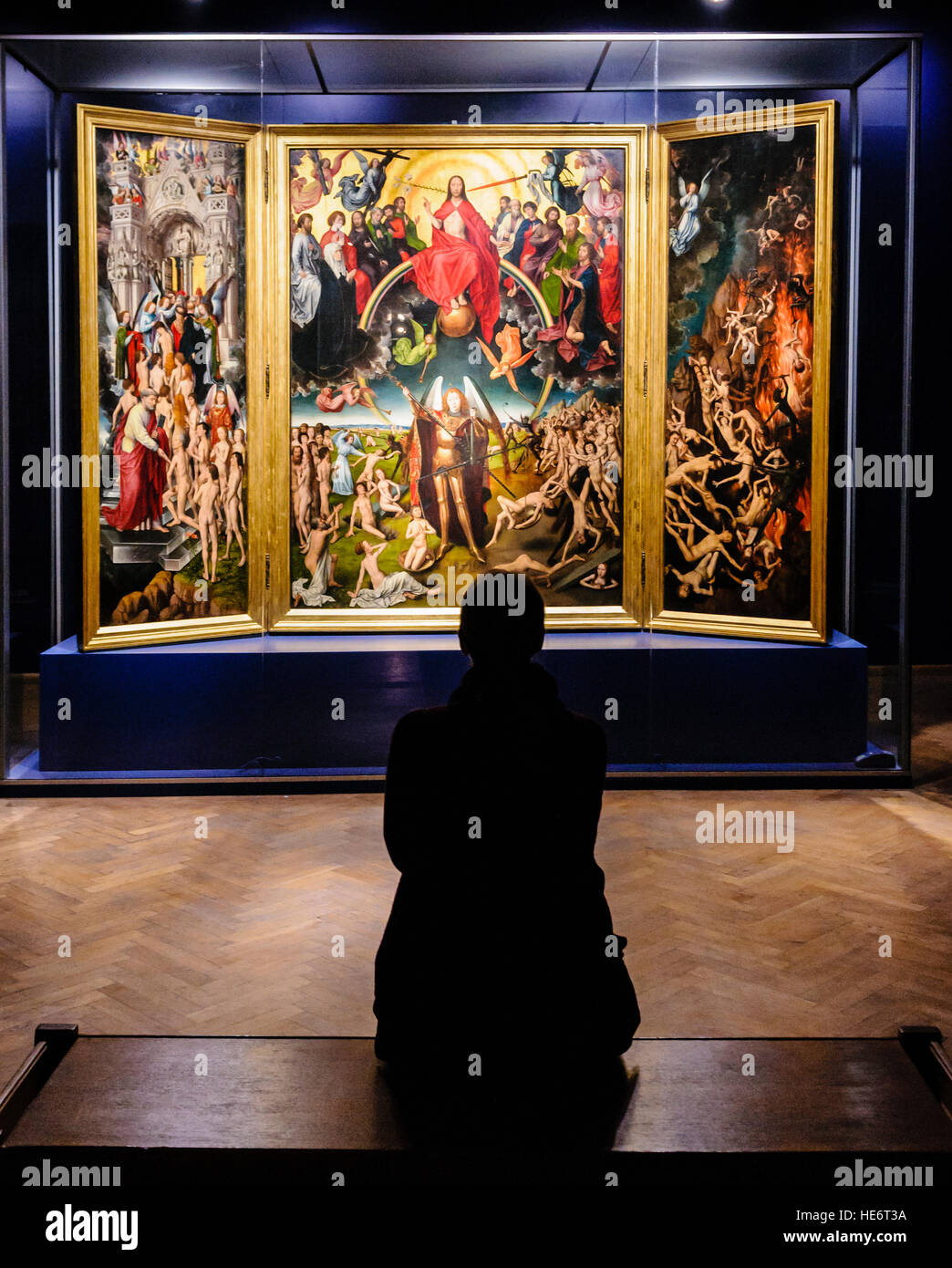 Eine Frau sitzt, wie sie das letzte Urteil des deutschen Malers Hans Memling im Nationalmuseum in Danzig in Polen bewundert Stockfoto