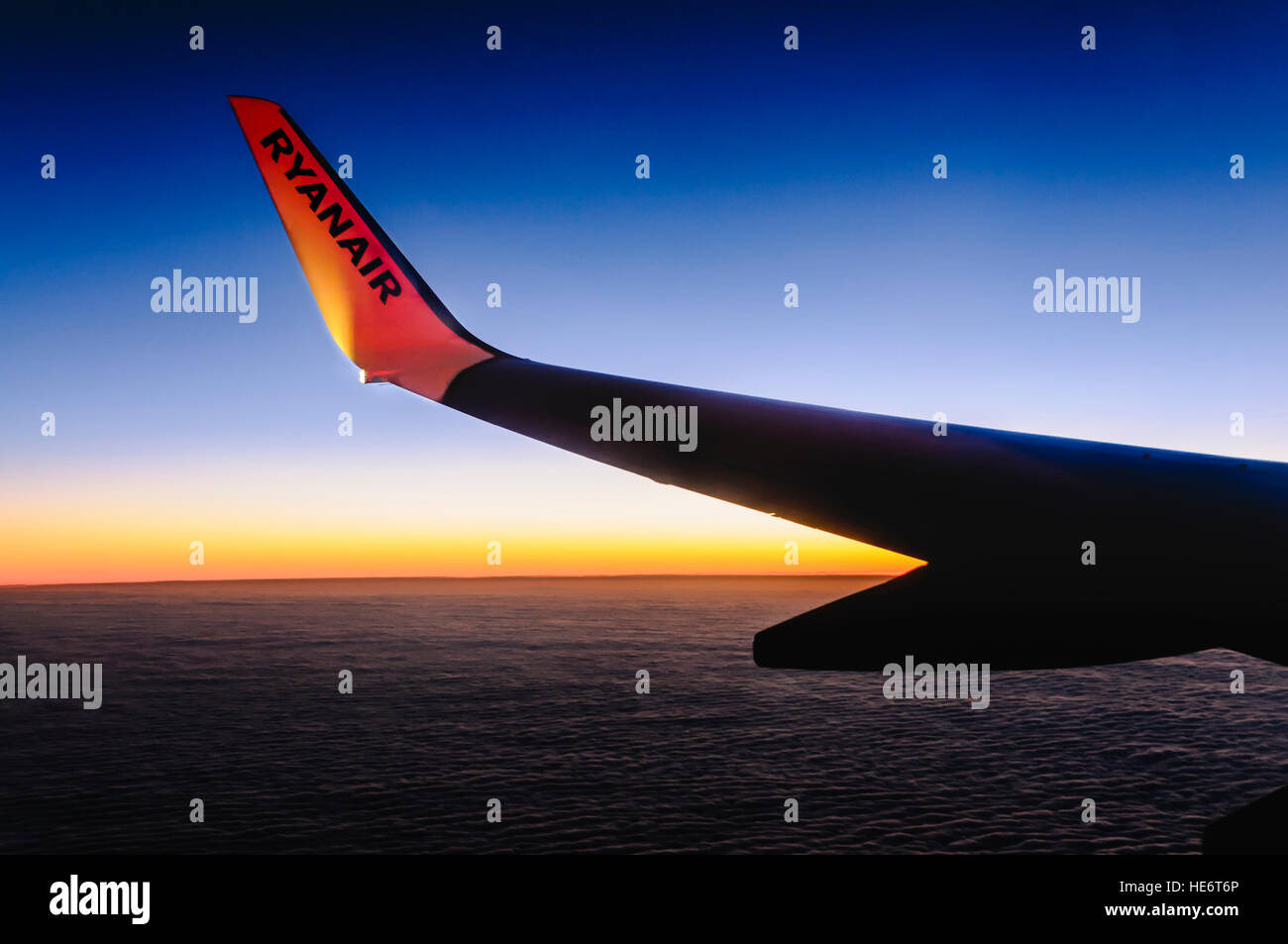Anzeigen von einem Ryanair-Flugzeug, wie es bei Sonnenaufgang fliegt. Stockfoto