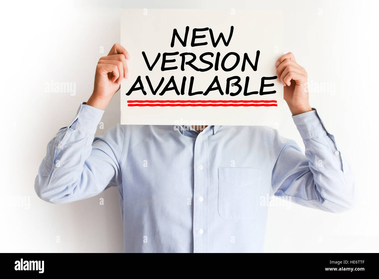 Neue Version verfügbar Konzept mit junger Mann hält eine Plakatwand Stockfoto