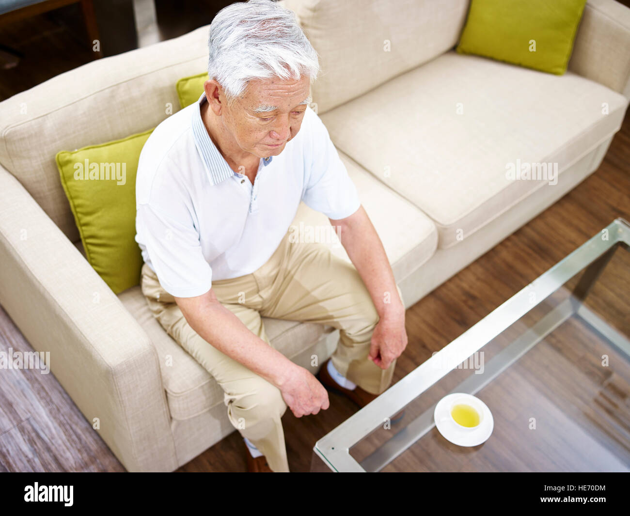 erhöhte Ansicht eines einsamen senior asiatischen Mannes auf Couch sitzen. Stockfoto