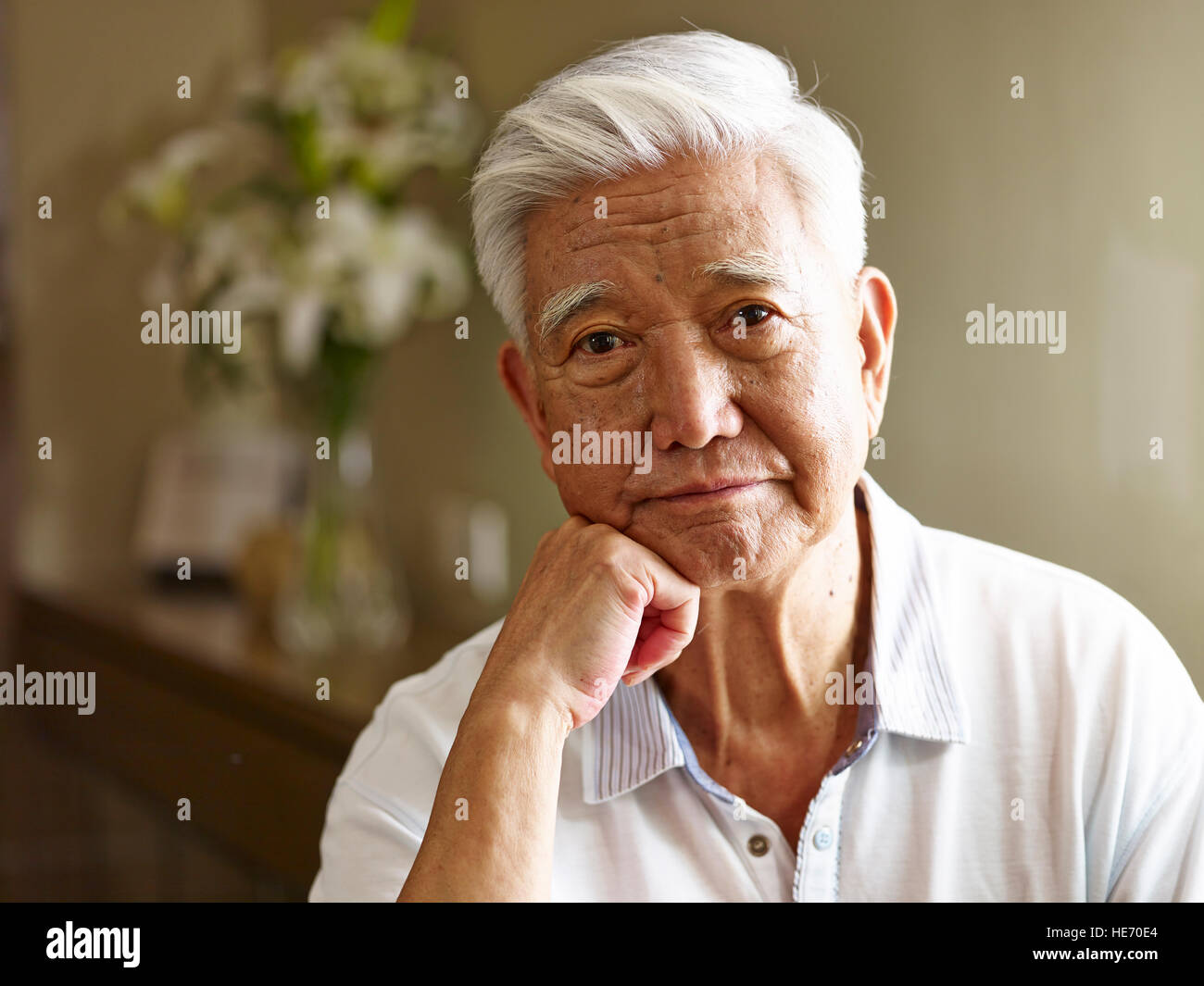 Porträt von trauriger senior asiatischen Mann Hand am Kinn, Vorderansicht. Stockfoto