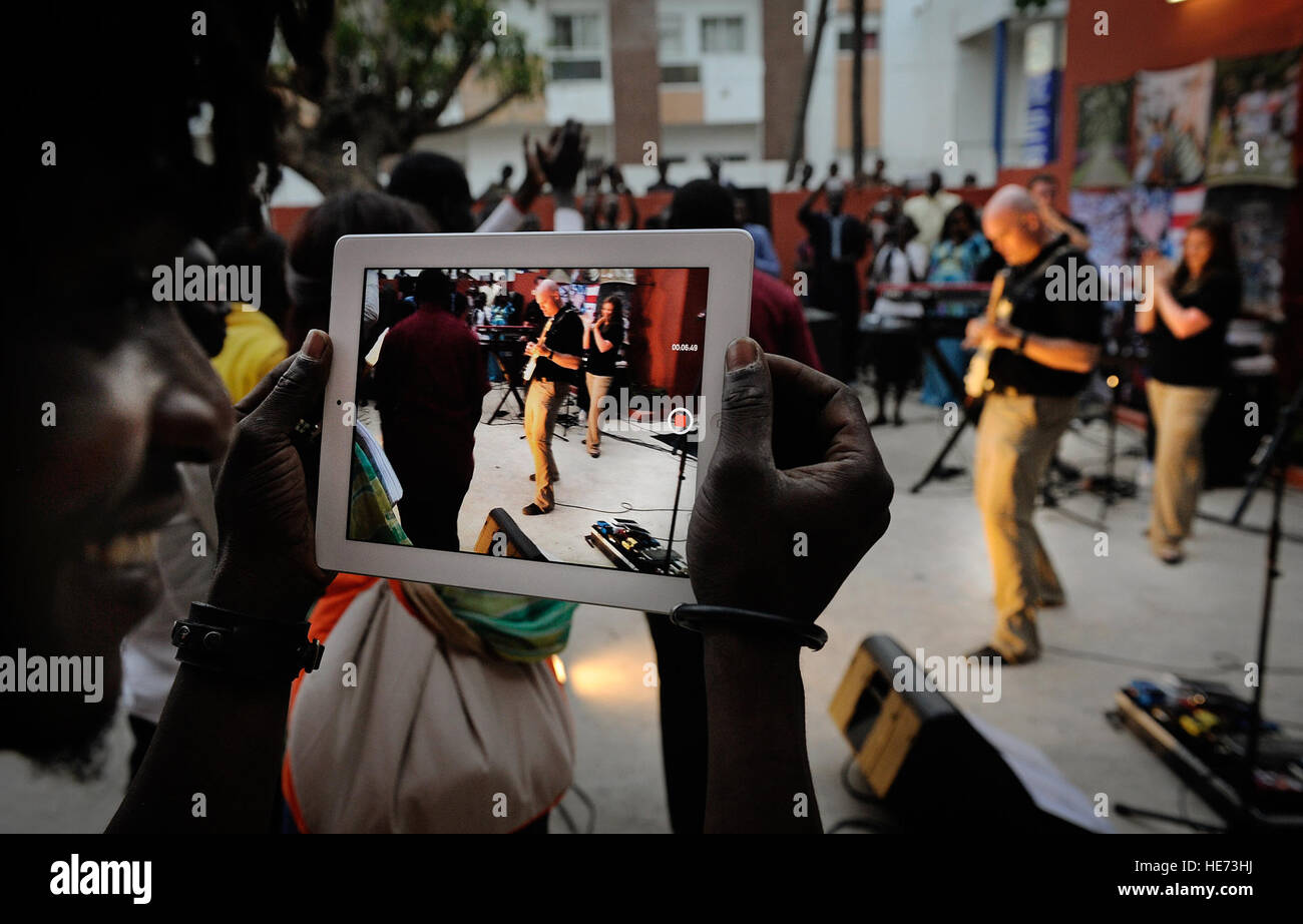 Ein Student an einer Universität vor Ort filmt die US-Luftstreitkräfte in Europa und Afrika Air Force Band Konzert in Dakar, Senegal, 13. Juni 2014. USAFE-AFAFRICA Flieger sind im Senegal für afrikanische Partnerschaft Flug, ein Programm zur Verbesserung der Kommunikation und Interoperabilität zwischen regionalen Partnern in Afrika. Die Band spielt mehrere Locations in der Umgebung, Kindern und Musikern durch die universelle Sprache der Musik zu begeistern.  Staff Sgt. Ryan Crane) Stockfoto