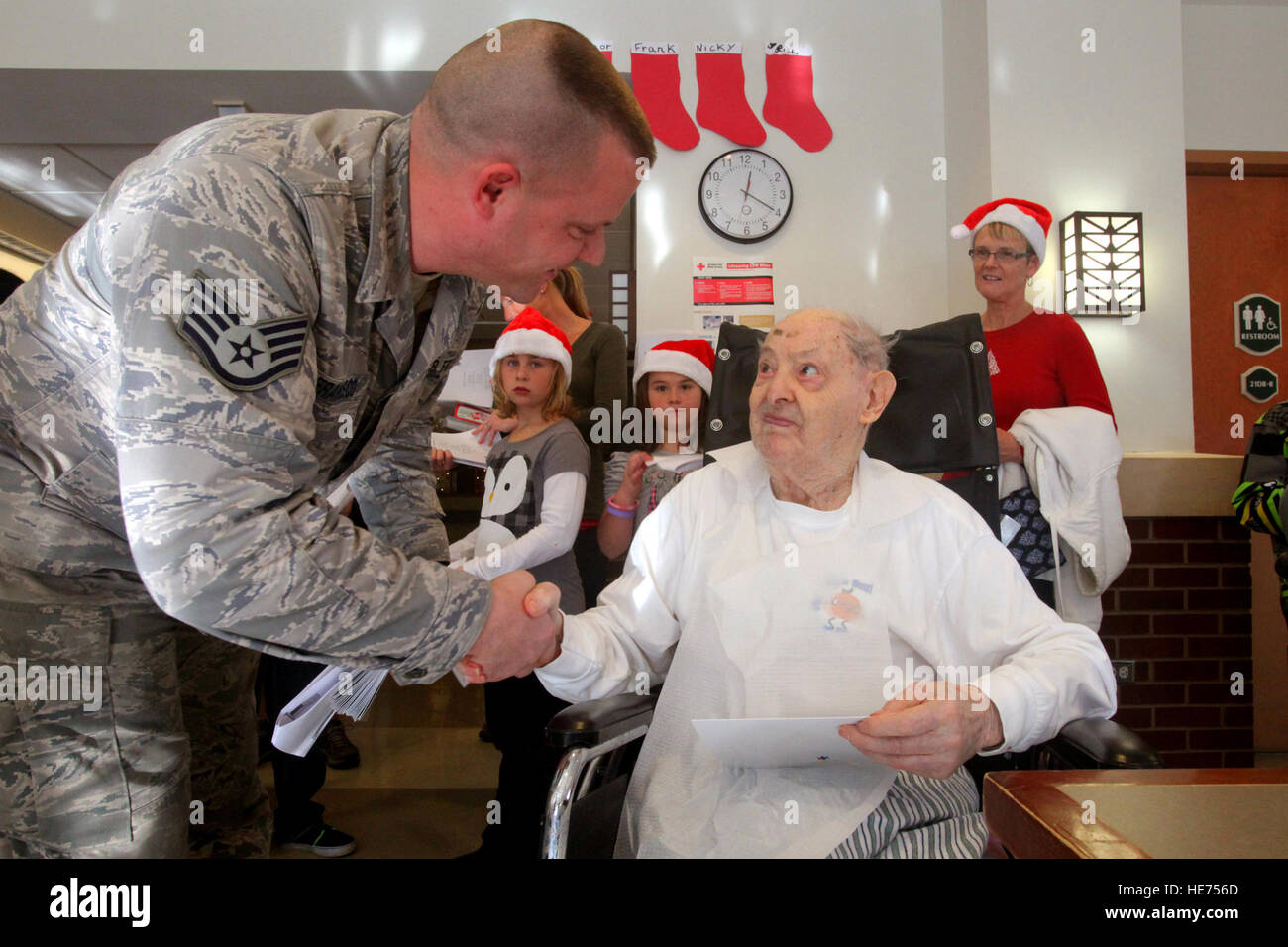 Staff Sgt Dominic Francesco, links, 177. Fighter Wing, schüttelt Hände mit Frank Cuccia, 103 Jahre alt und der älteste Bewohner zuhause die Vineland Veterans Memorial in Vineland, NJ, 14. Dezember 2011. Flieger aus der 177. Kämpfer-Flügel und der 108. Flügel, beide zugewiesen, der New Jersey Air National Guard, gesellten sich Viertklässler aus den Blick aufs Meer-Schule in Linwood, N.J. für den 11. jährlichen Urlaub 'Songfest' Zuhause Vineland.  Bei der Ankunft waren Flieger und Viertklässler ausgestellt Zuckerstangen und Urlaub Grußkarten, Gruppen zugeordnet und ausgesandt, um die Stimmung unter den Bewohnern verteilt. Stockfoto