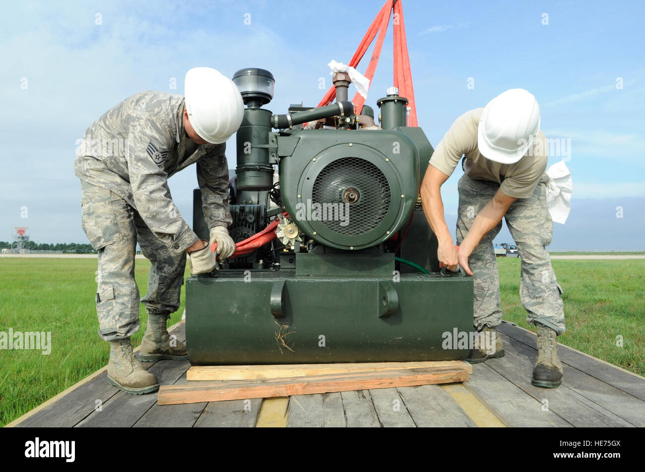 Staff Sgt Sheldon Mellott, links, 8. Civil Engineer Squadron schwere Ausrüstung Betreiber und Staff Sgt Michael Brennan, 8. CES macht Produktion Handwerker, Aushängen eines Flugzeuges verhaften System nach dem Laden auf einen Flachbettscanner auf Kunsan Air Base, Republik Korea, 21. August 2012. Nach fast einen Fuß Regen hier letzte Woche die Bremssysteme standen unter Wasser und musste verlegt werden. Stockfoto