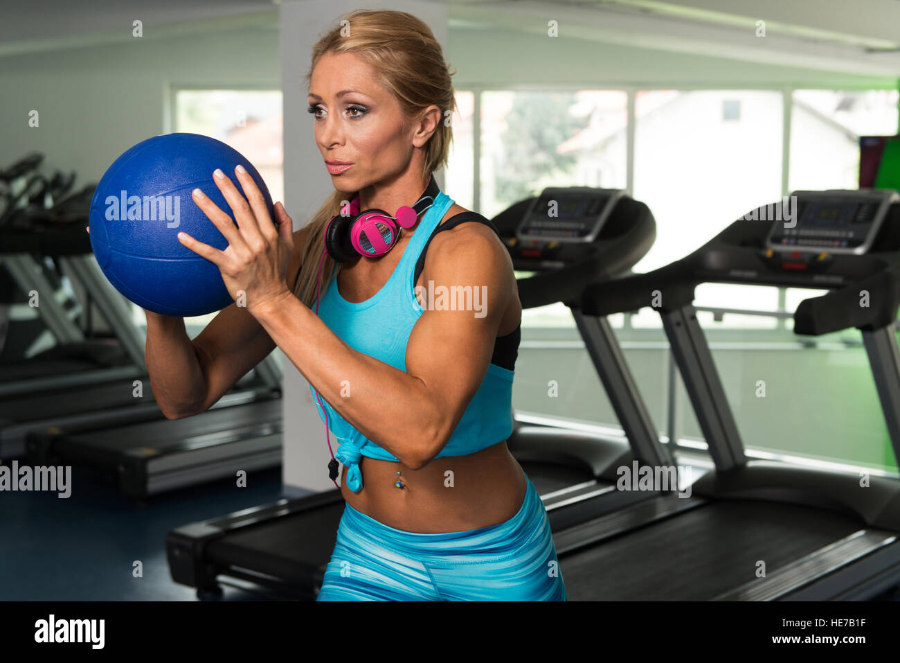 Reife Frau, die das Training mit Medizinball In der Turnhalle und biegen Muskeln - muskulöse athletische Bodybuilder Fitness-Modell Stockfoto