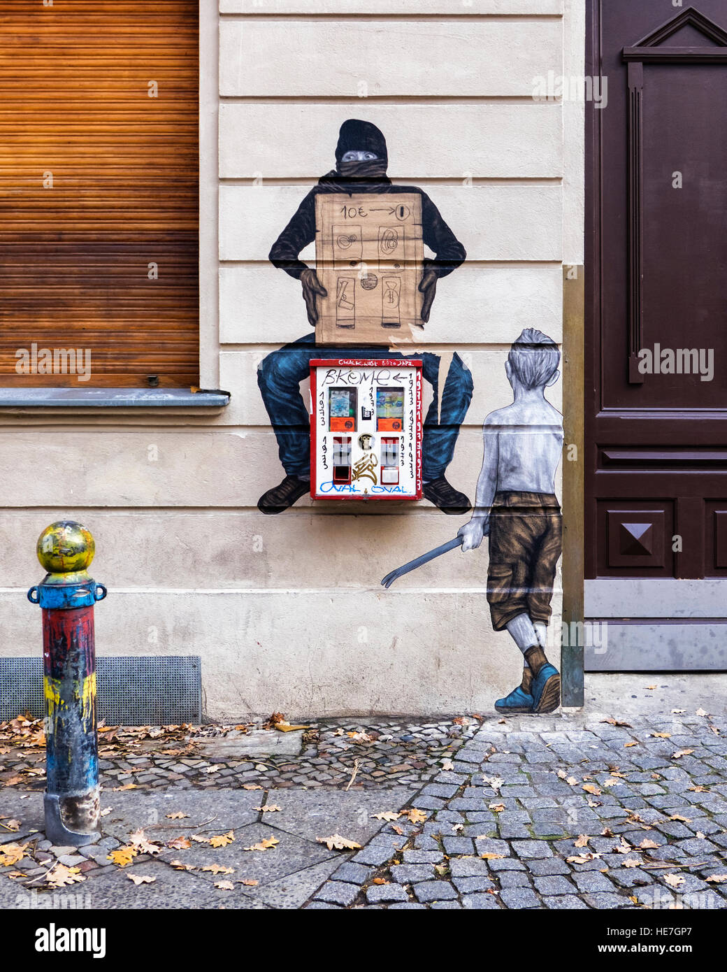 Berliner Straße Kunst rund um Kaugummi Spender. Junge, Brecheisen, Gumball Maschine, Mann in balaclava Stockfoto